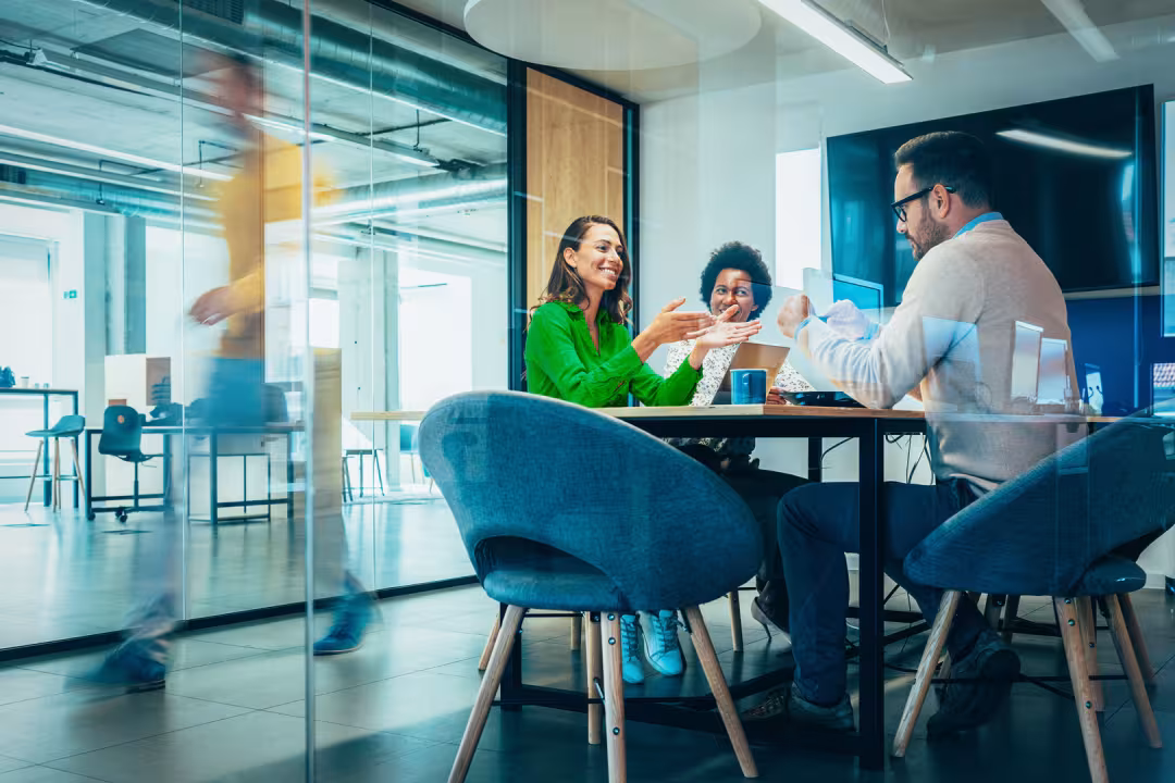 Drie collega's hebben een informele bespreking op kantoor.