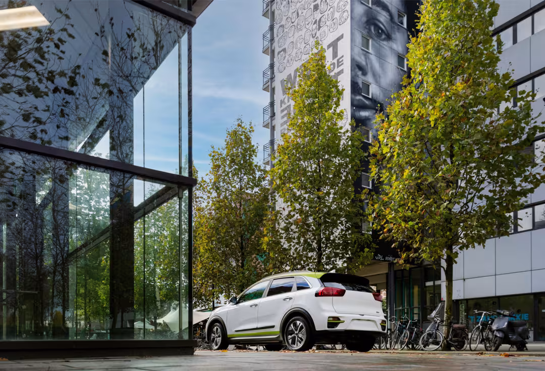 Een flitsende witte auto staat geparkeerd in een modern, zakelijk district.